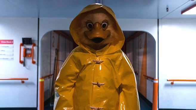Quacky: alguien disfrazado de pato gigante con poncho impermeable amarillo