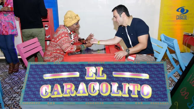Mujer leyéndole la mano al periodista Juan Diego Alvira, de Caracol Televisión