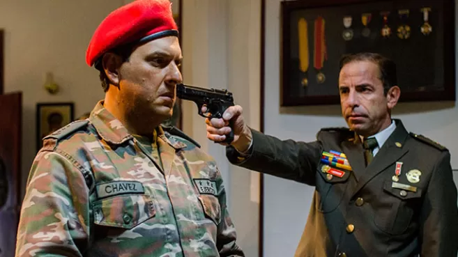 Andrés Parra siendo apuntado con un arma en la serie "Hugo Chávez, El Comandante"