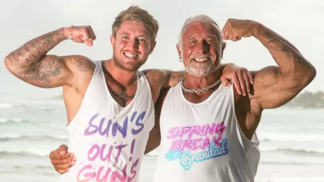 Joven con su abuelo, en la playa, mostrando los biceps