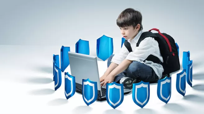 Niño estudiante trabajando en su portátil, rodeado por escudos azules de antivirus