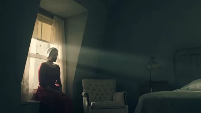 Elisabeth Moss como Offred en "The Handmaid’s Tale", sentada en la ventana de su habitación