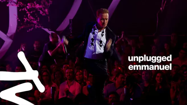 Emmanuel con traje negro y camisa blanca cantando en su "Emmanuel: MTV Unplugged"