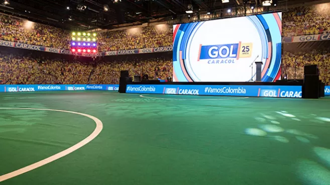 Tarima con pantalla LED gigante con logo de Gol Caracol, en escenario que simula un estadio de fútbol