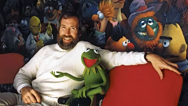 Jim Henson, creador de Los Muppets, sentado al lado de La Rana René junto a un mural de Los Muppets