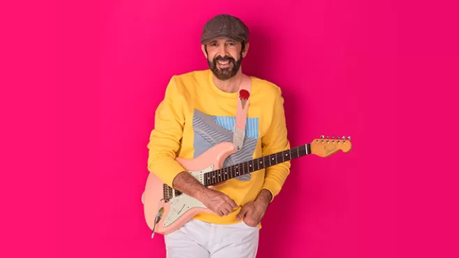 Foto de Juan Luís Guerra con una guitarra