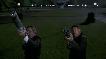 Tommy Lee Jones y Will Smith apuntando sus armas en una escena de Hombres de Negro (Men in Black)