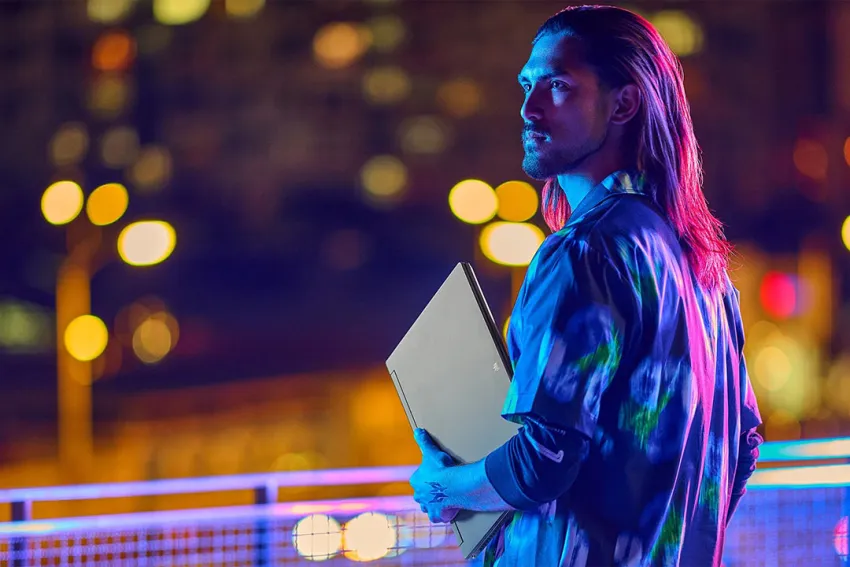 Hombre joven con una laptop gaming en su mano izquierda