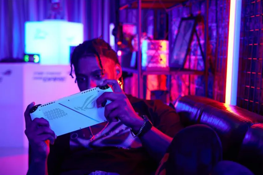 Hombre jóven sobre un sofá, jugando con la consola ROG Ally