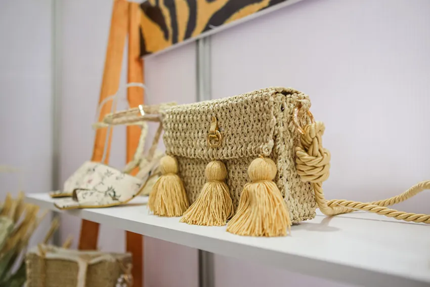 Bolso artesanal y calzado de dama sobre repisa blanca