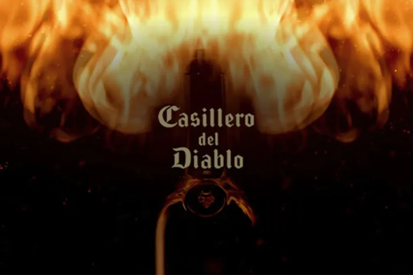 Botella de vino Casillero del Diablo rodeada de fuego