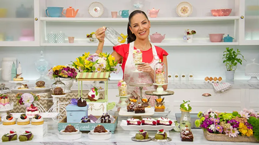 Chef Paulina Abascal con muchos postres sobre la mesa