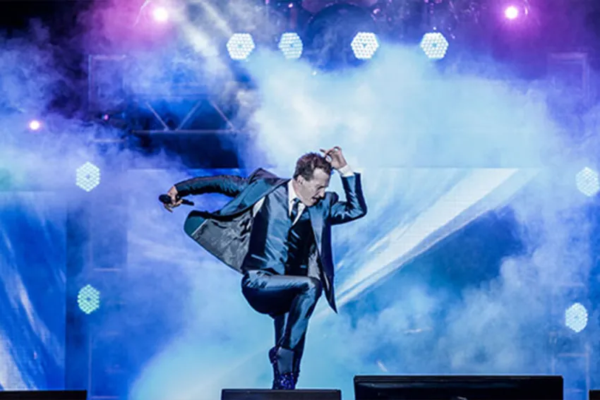 Emmanuel haciendo su icónica pose en la tarima durante un concierto