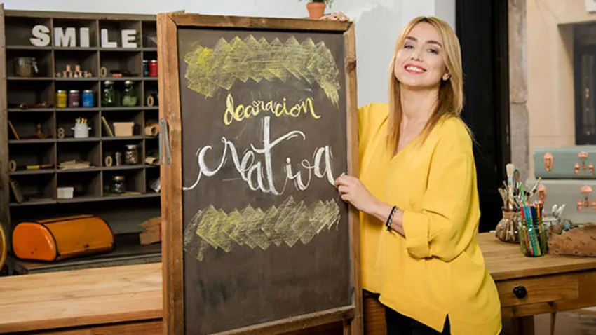 Gema Casado vestida de amarillo sosteniendo una pizarra