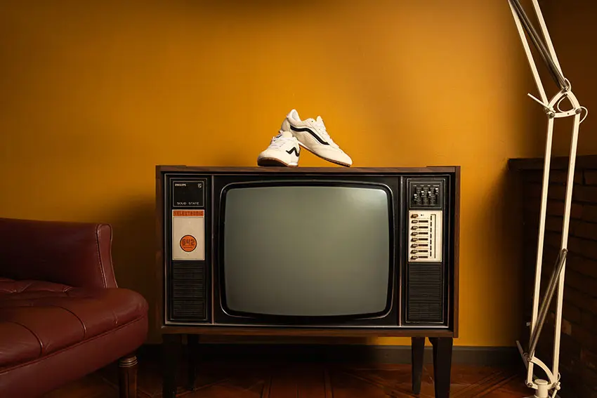 Zapatos Vans Super Lowpro blancos sobre un televisor antiguo