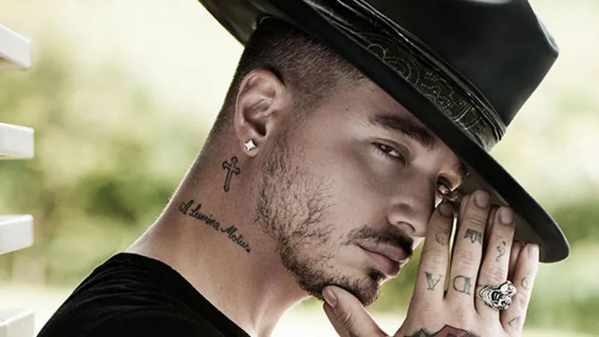 J Balvin con sombrero negro y las manos juntas en señal de oración