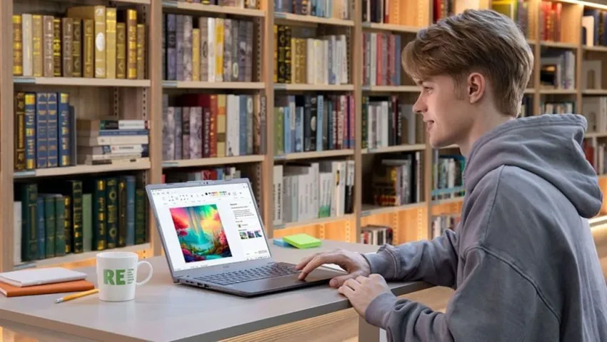 Joven utilizando un computador portátil en una biblioteca