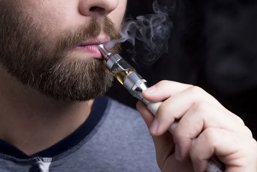 Hombre joven usando un vapeador