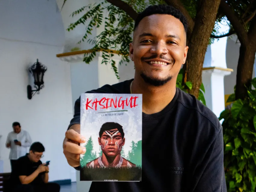 Yomar Edna sosteniendo su primer libro titulado "Kasingui"