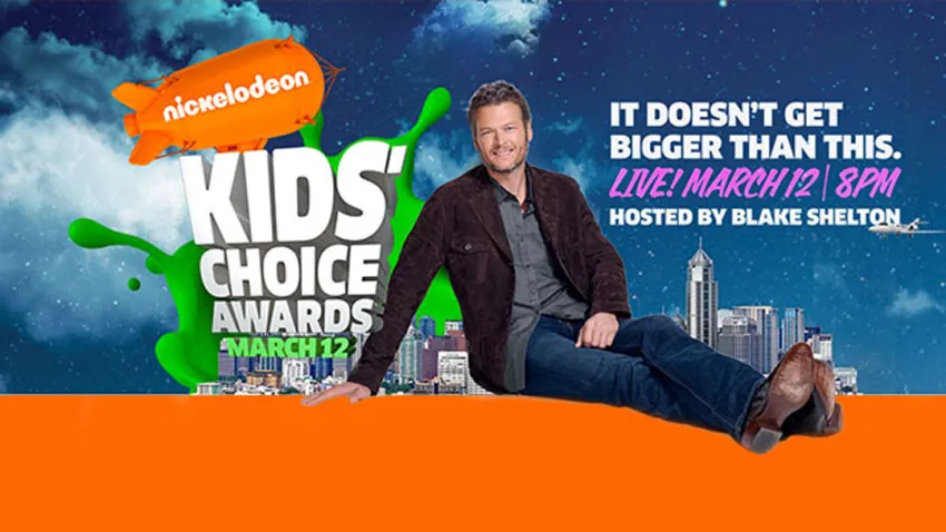 Blake Shelton sentado junto al logo de los KCA 2016