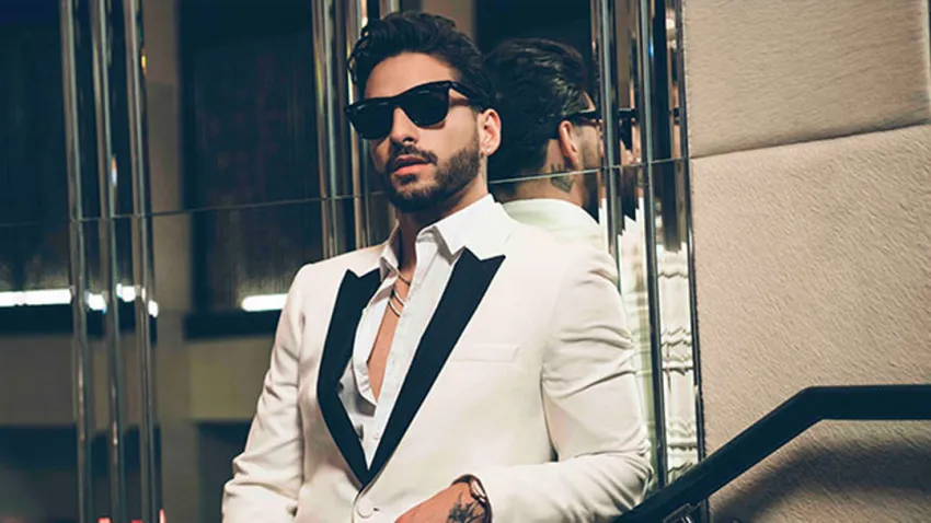 Maluma con gafas oscuras y un traje blanco de cuello negro