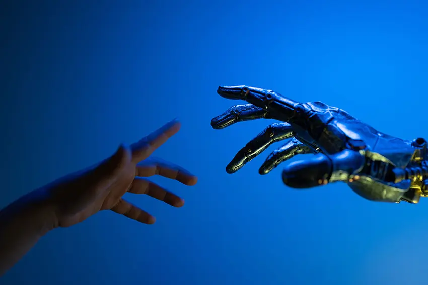 Mano humana tratando de alcanzar mano robótica