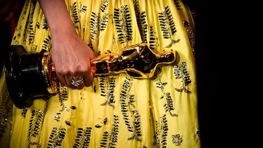 Mano de mujer sosteniendo un Premio Oscar