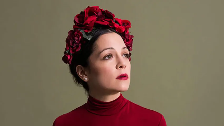 Natalia Lafourcade vestida de rojo y con rosas rojas en la cabeza