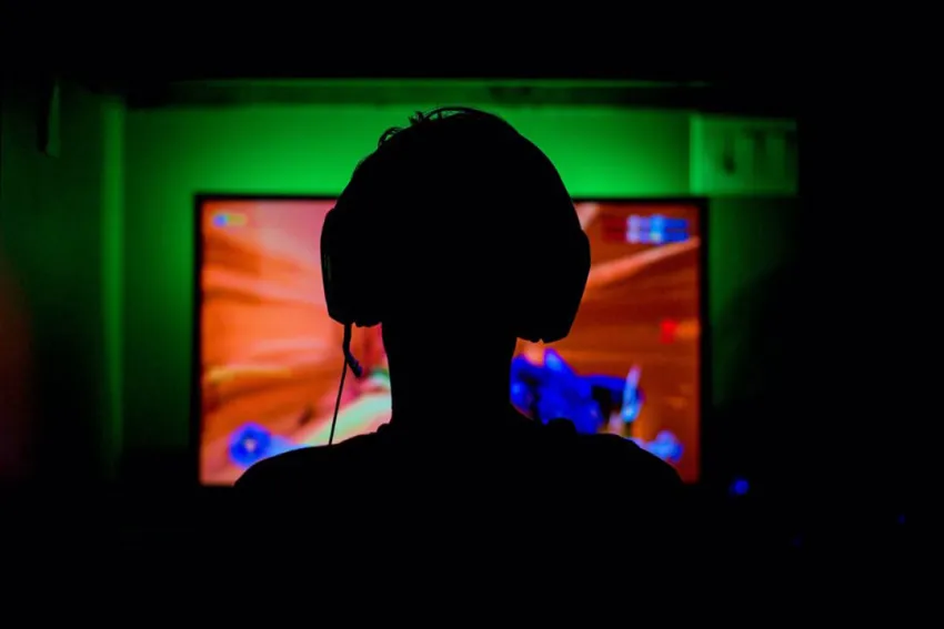 Silueta de hombre gamer jugando videojuegos en su computador