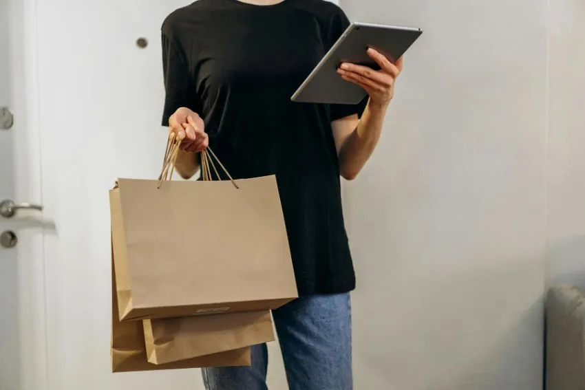 Persona con bolsas de compras y ipad en las manos