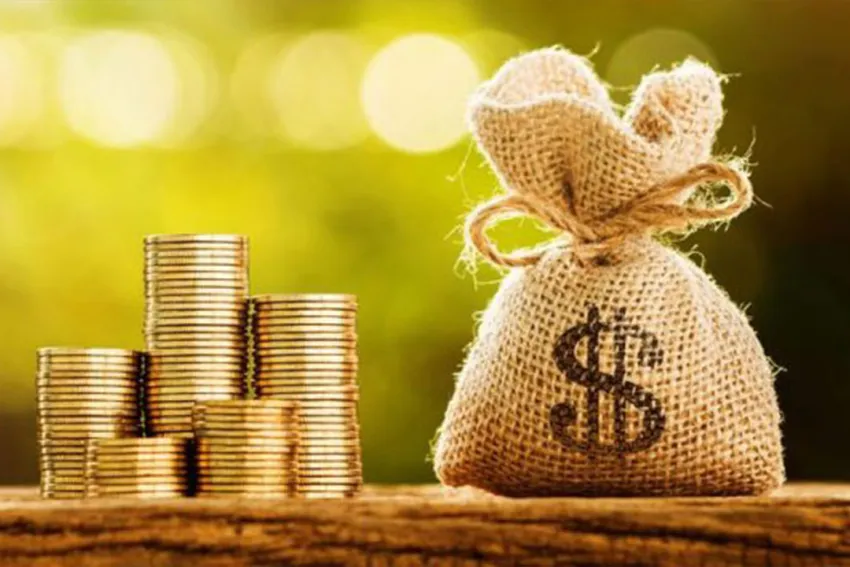 Pila de monedas al lado de un saco de dinero