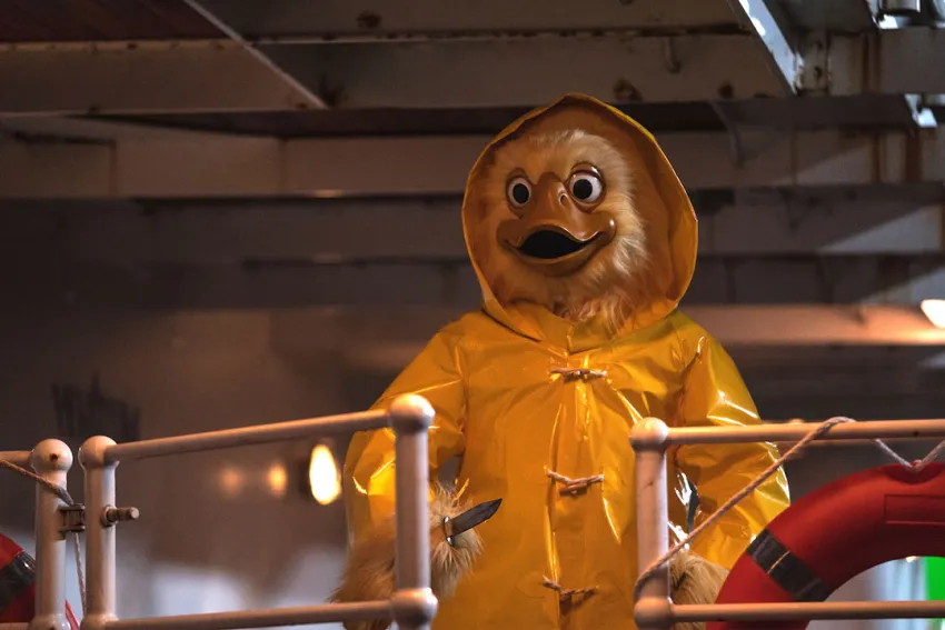 Quacky: alguien disfrazado de pato gigante con poncho impermeable amarillo