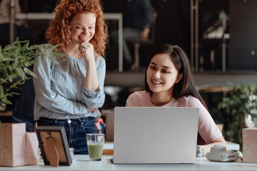 Dos mujeres jóvenes viendo la pantalla de una laptop