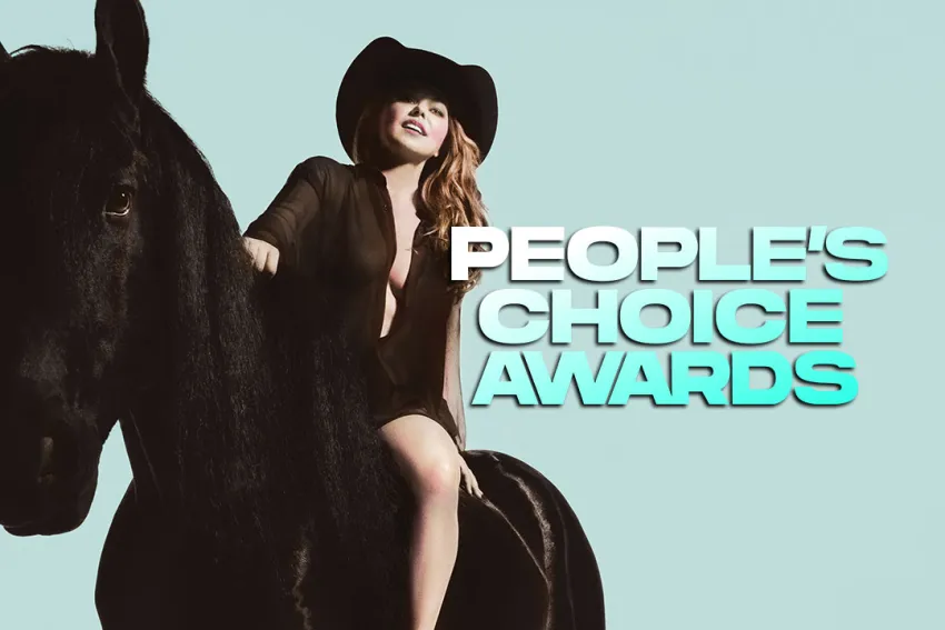 Shania Twain con sombrero y vestido negro montada en un caballo negro