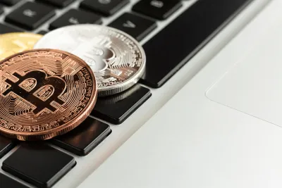 Monedas metálicas de Bitcoin sobre el teclado de un computador portátil