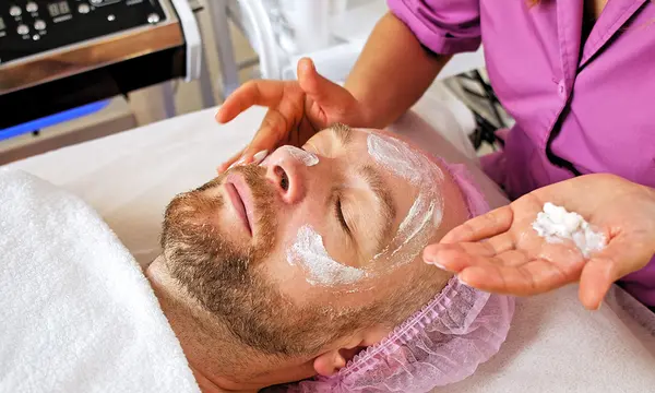 Cosmetóloga hace tratamiento estético facial a hombre