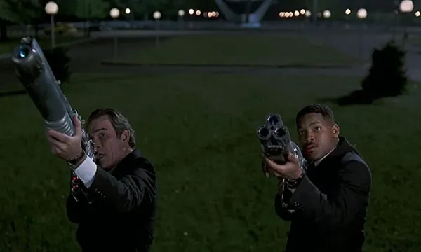 Tommy Lee Jones y Will Smith apuntando sus armas en una escena de Hombres de Negro (Men in Black)