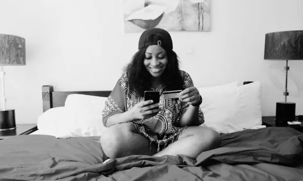 Mujer pagando con tarjeta desde su dispositivo móvil