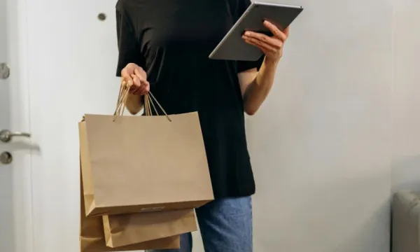 Persona con bolsas de compras y ipad en las manos
