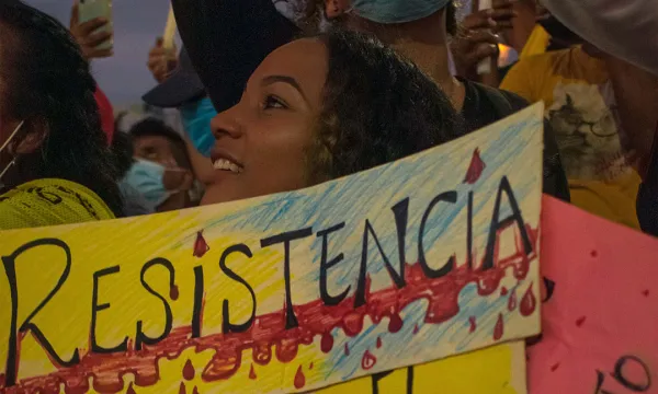 Mujer jóven en marcha pacífica de Cartagena sostiene una pancarta que dice "Resistencia"