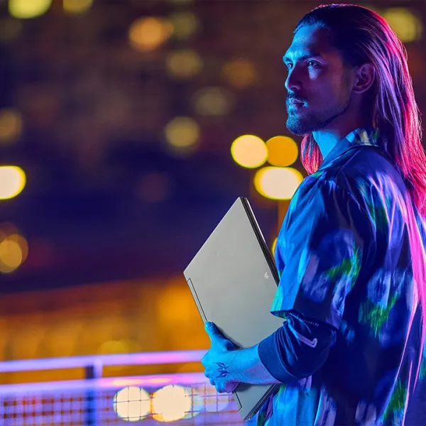 Hombre joven con una laptop gaming en su mano izquierda