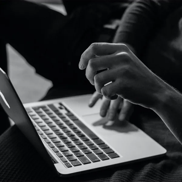 Manos de hombre estudiando virtualmente desde su computador portátil