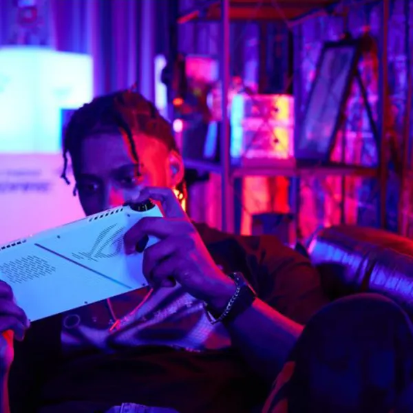 Hombre jóven sobre un sofá, jugando con la consola ROG Ally