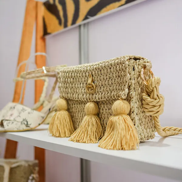 Bolso artesanal y calzado de dama sobre repisa blanca