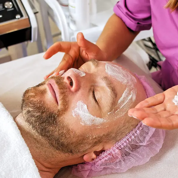 Cosmetóloga hace tratamiento estético facial a hombre