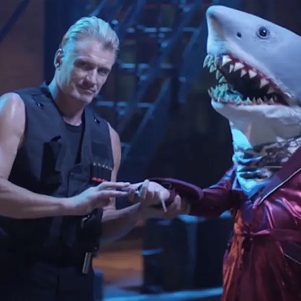 Dolph Lundgren recibiendo llaves de parte de un tiburón vestido de pijama
