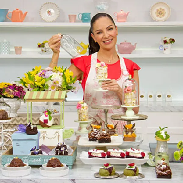 Chef Paulina Abascal con muchos postres sobre la mesa
