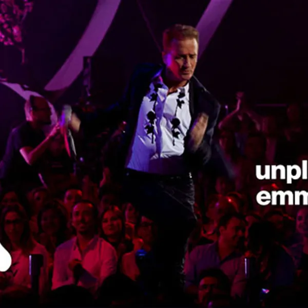 Emmanuel con traje negro y camisa blanca cantando en su "Emmanuel: MTV Unplugged"