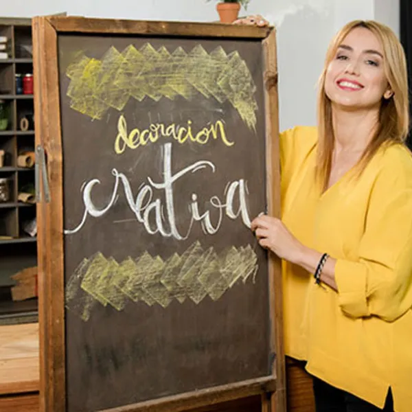 Gema Casado vestida de amarillo sosteniendo una pizarra