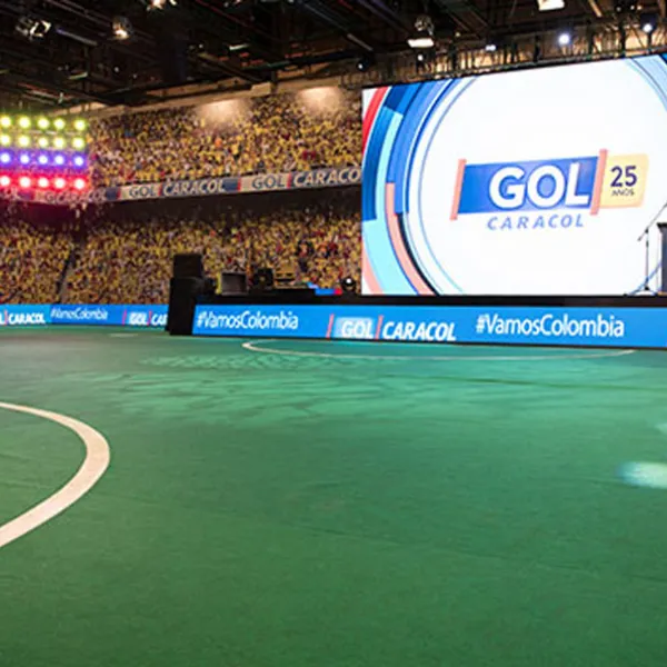 Tarima con pantalla LED gigante con logo de Gol Caracol, en escenario que simula un estadio de fútbol